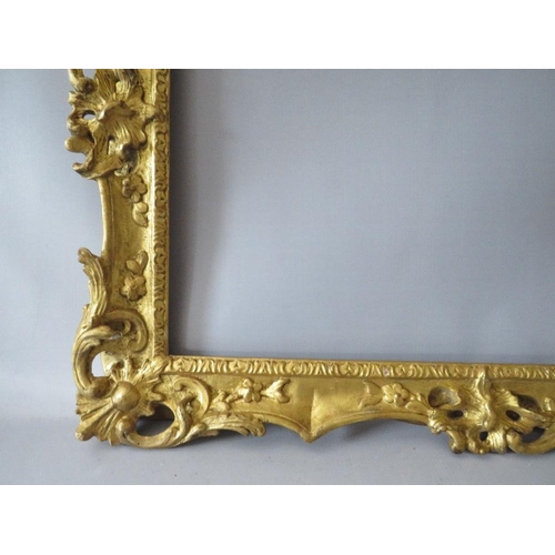84 - A 19TH CENTURY CARVED WOODEN DECORATIVE GILT SWEPT FRAME, frame W 7 cm, rebate 58 x 42 cm