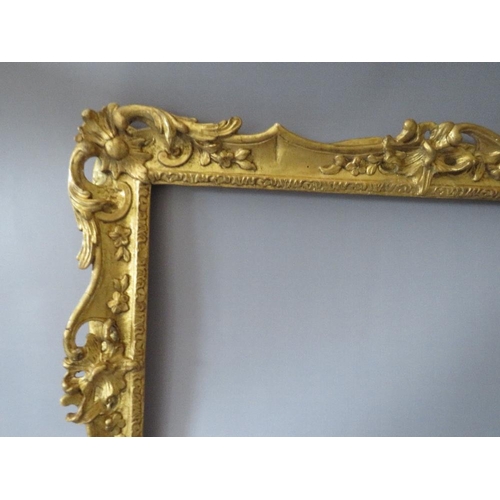 84 - A 19TH CENTURY CARVED WOODEN DECORATIVE GILT SWEPT FRAME, frame W 7 cm, rebate 58 x 42 cm