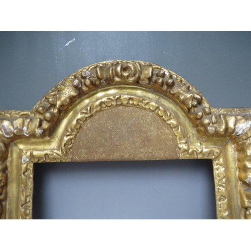 91 - A 17TH CENTURY CONTINENTAL DECORATIVE CARVED WOODEN FRAME WITH ARCHED TOP, frame W 7 cm, rebate 40 x... 