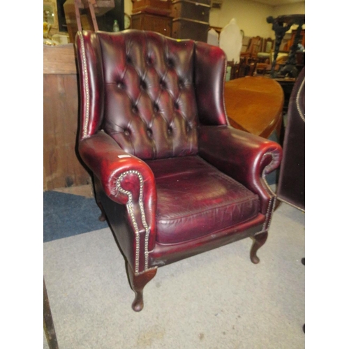 735 - AN OXBLOOD RED LEATHER WINGBACK ARMCHAIR BY MARTIN BARNES LONDON TOGETHER WITH A STOOL