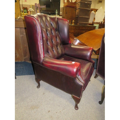 735 - AN OXBLOOD RED LEATHER WINGBACK ARMCHAIR BY MARTIN BARNES LONDON TOGETHER WITH A STOOL