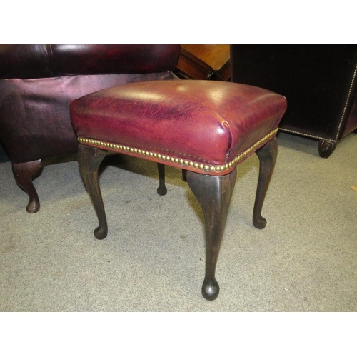 735 - AN OXBLOOD RED LEATHER WINGBACK ARMCHAIR BY MARTIN BARNES LONDON TOGETHER WITH A STOOL