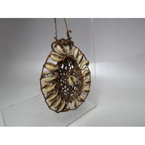 915 - A VINTAGE PAPUA NEW GUINEA PENDANT NECKLACE, comprised of string and cowrie shells, pendant 9 x 8 cm