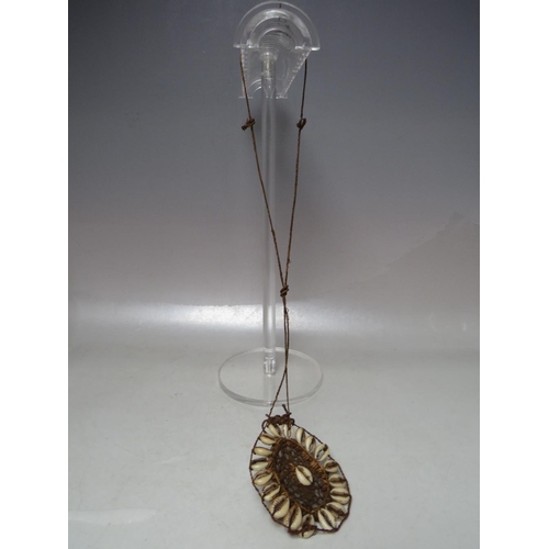 915 - A VINTAGE PAPUA NEW GUINEA PENDANT NECKLACE, comprised of string and cowrie shells, pendant 9 x 8 cm