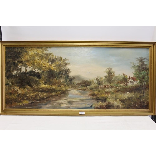 6 - A GILT FRAMED OIL ON BOARD OF A RURAL RIVER LANDSCAPE WITH COTTAGE 45CM X 106CM