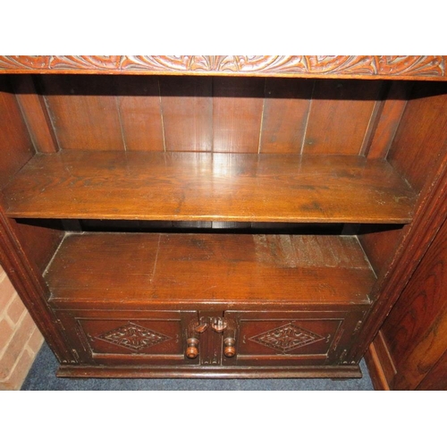 644 - A CARVED REPRODUCTION OAK OPEN BOOKCASE WITH CUPBOARD BELOW W-85 CM