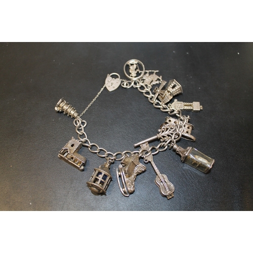 285 - A VINTAGE SILVER CHARM BRACELET WITH LARGE CHARMS