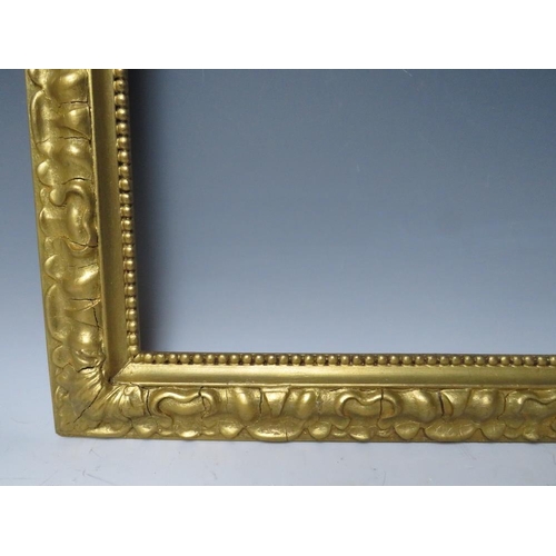 102 - A LATE 19TH / EARLY 20TH CENTURY DECORATIVE GOLD FRAME, with bead design to inner edge and plant des... 