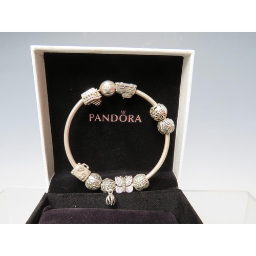 244 - A PANDORA CHARM BRACELET WITH ATTACHED CHARMS, together with a collection of empty Pandora boxes (8 ... 