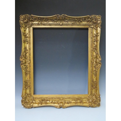 51 - A 19TH CENTURY DECORATIVE GOLD SWEPT FRAME, frame W 9 cm, rebate 62 x 51 cm