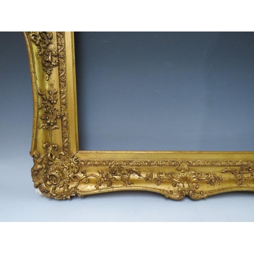 51 - A 19TH CENTURY DECORATIVE GOLD SWEPT FRAME, frame W 9 cm, rebate 62 x 51 cm