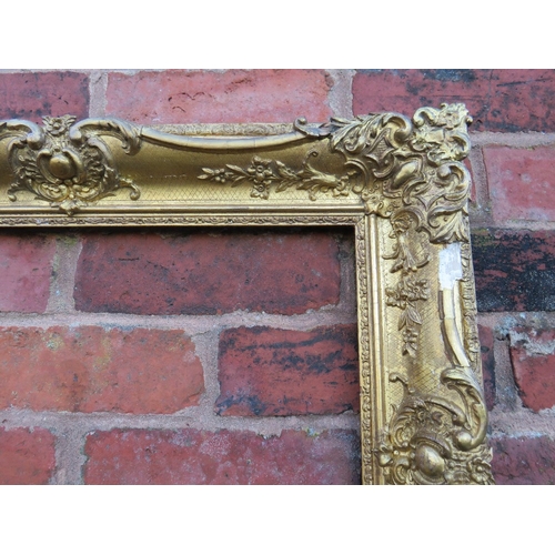 56 - A 19TH CENTURY DECORATIVE GOLD SWEPT FRAME, frame W 10 cm, rebate 54 x 36 cm