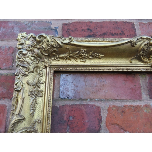 56 - A 19TH CENTURY DECORATIVE GOLD SWEPT FRAME, frame W 10 cm, rebate 54 x 36 cm