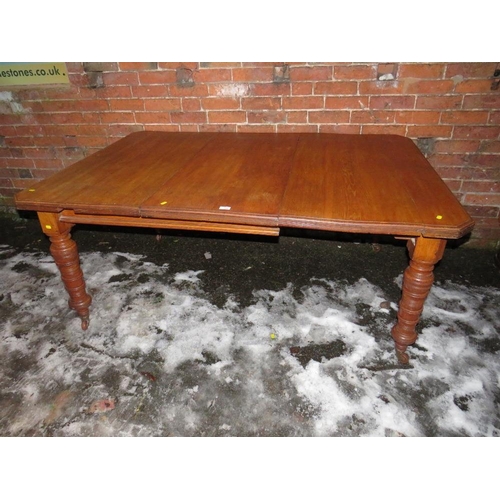 750 - AN EDWARDIAN OAK WIND-OUT DINING TABLE WITH ONE SPARE LEAF