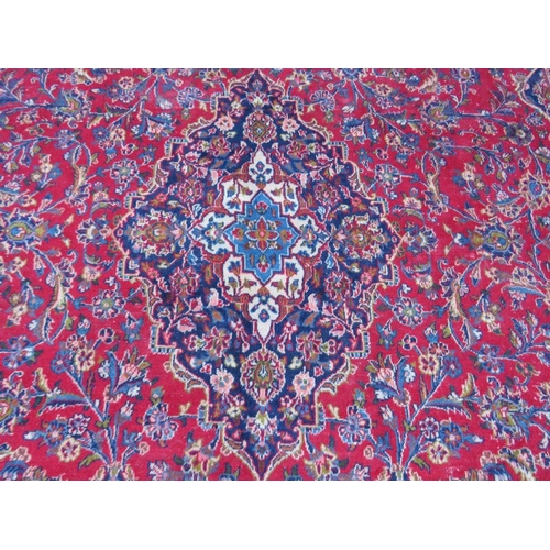 886 - A LARGE RED / BLUE GROUND CARPET, APPROX 389 X 297 CM - WEAR THROUGHOUT