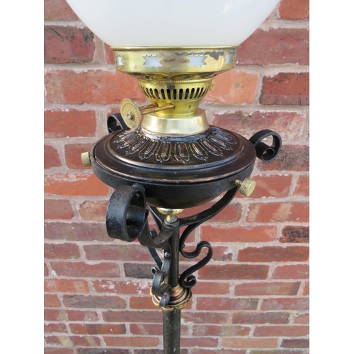 401 - A WROUGHT IRON FLOOR STANDING OIL LAMP, having scrollwork decorations, hammered copper floral embell... 