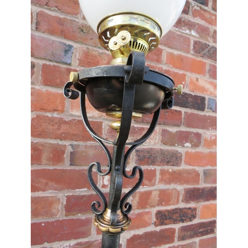 401 - A WROUGHT IRON FLOOR STANDING OIL LAMP, having scrollwork decorations, hammered copper floral embell... 