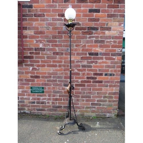 401 - A WROUGHT IRON FLOOR STANDING OIL LAMP, having scrollwork decorations, hammered copper floral embell... 