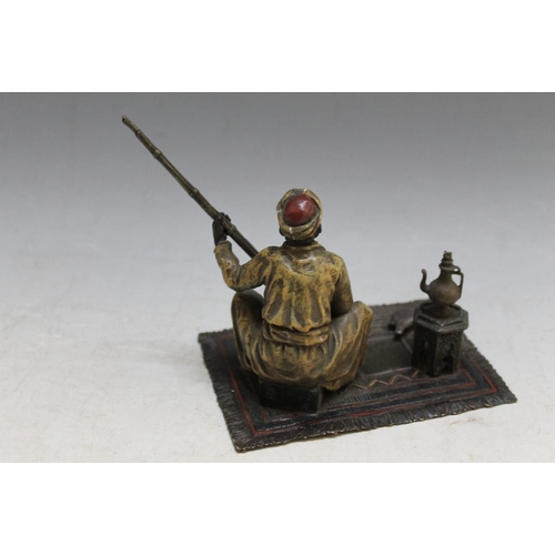 411 - AN AUSTRIAN STYLE COLD PAINTED BRONZE OF AN ARAB GENTLEMAN SEATED ON A CARPET WITH A GUN, W 15 cm