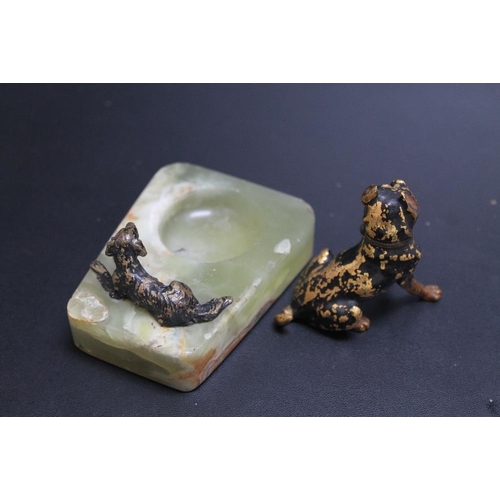 420 - A SMALL COLD PAINTED DOG ON AN ONYX DISH, together with another dog, H 6 cm (2)