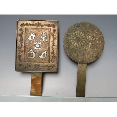 463 - TWO BRONZE JAPANESE HAND MIRRORS. together with three decorated bronze plates and a bronze relief po... 