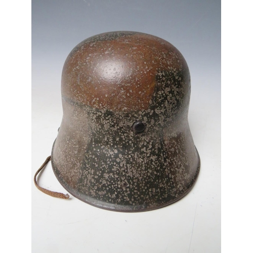 506 - A GERMAN M16 CAMOUFLAGE HELMET, complete with internal webbing