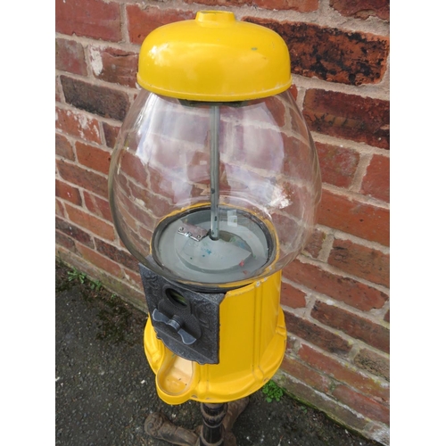 521 - A VINTAGE AMERICAN GUMBALL MACHINE ON CAST IRON BASE, with yellow painted alloy body and glass globe... 