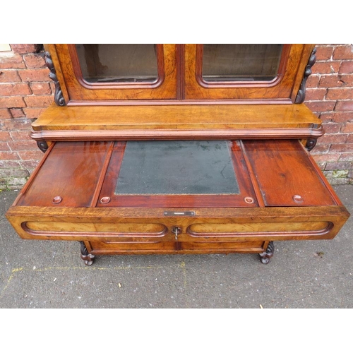 587 - A 19TH CENTURY WALNUT GLAZED BOOKCASE, the upper section with twin glazed doors and carved moulded d... 