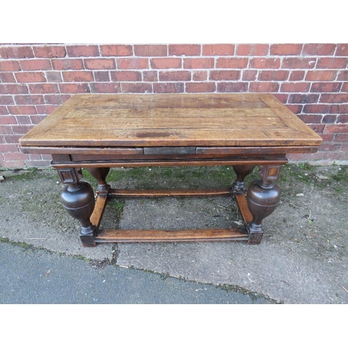 604 - AN ANTIQUE OAK DRAWLEAF REFECTORY TABLE, raised on four baluster supports united by well-worn stretc... 