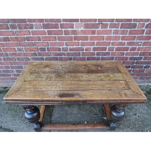 604 - AN ANTIQUE OAK DRAWLEAF REFECTORY TABLE, raised on four baluster supports united by well-worn stretc... 