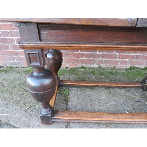 604 - AN ANTIQUE OAK DRAWLEAF REFECTORY TABLE, raised on four baluster supports united by well-worn stretc... 