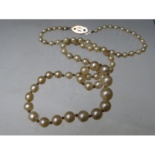 263 - A SINGLE STRAND HAND KNOTTED GRADUATED PEARL NECKLACE WITH 9CT WHITE GOLD CLASP, the clasp set with ... 