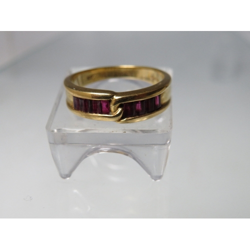 272 - AN 18CT GOLD GEMSET RING, of simple crossover design  with 8 baguette cut channel set ruby type gems... 