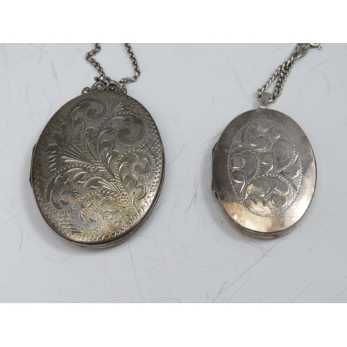 257 - TWO OVAL SILVER PENDANT LOCKETS ON CHAINS, together with a smaller heart shaped example (3)