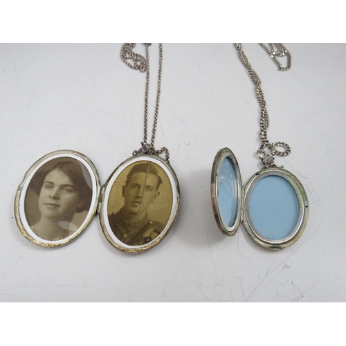 257 - TWO OVAL SILVER PENDANT LOCKETS ON CHAINS, together with a smaller heart shaped example (3)