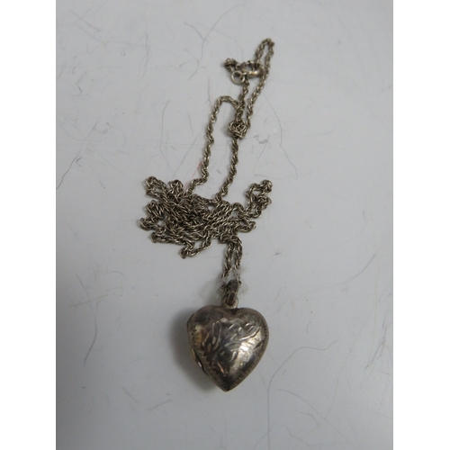 257 - TWO OVAL SILVER PENDANT LOCKETS ON CHAINS, together with a smaller heart shaped example (3)