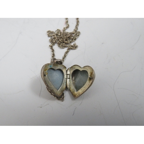 257 - TWO OVAL SILVER PENDANT LOCKETS ON CHAINS, together with a smaller heart shaped example (3)