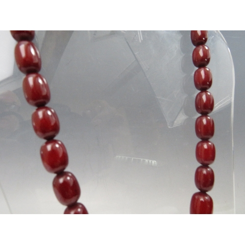 274 - A VINTAGE CHERRY AMBER GRADUATED BEAD NECKLACE, single strand with screw barrel fastening, central b... 