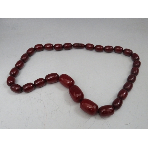 274 - A VINTAGE CHERRY AMBER GRADUATED BEAD NECKLACE, single strand with screw barrel fastening, central b... 