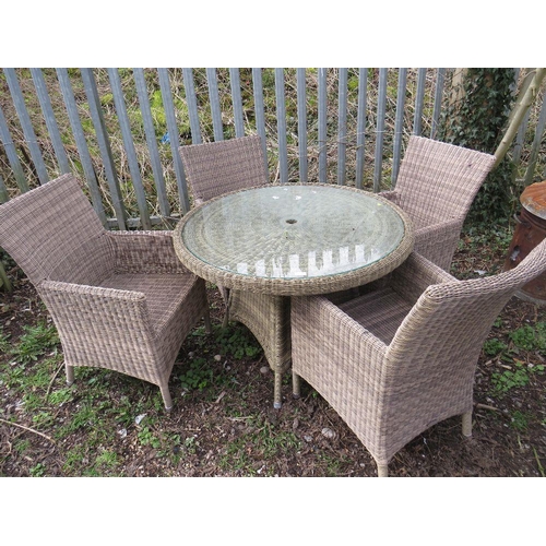 665 - A MODERN CIRCULAR RATTAN PATIO TABLE AND FOUR CHAIRS