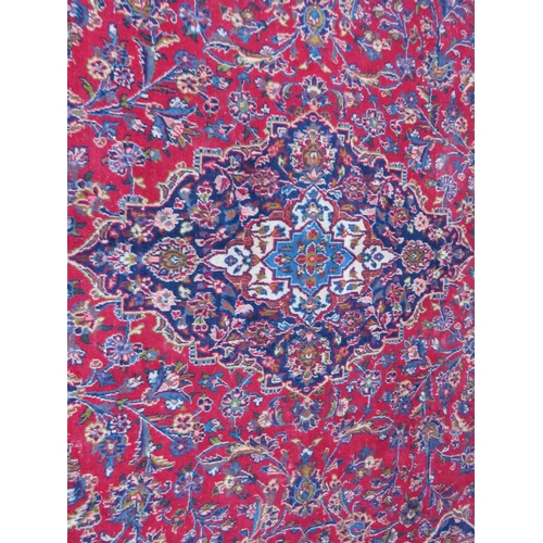 881 - A LARGE RED / BLUE GROUND CARPET, APPROX 389 X 297 CM - WEAR THROUGHOUT