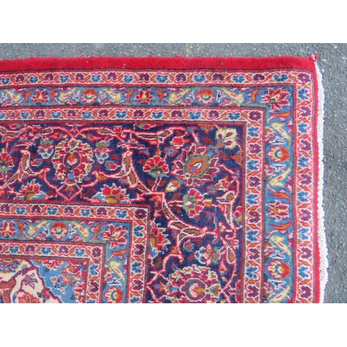 881 - A LARGE RED / BLUE GROUND CARPET, APPROX 389 X 297 CM - WEAR THROUGHOUT