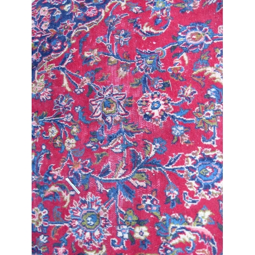 881 - A LARGE RED / BLUE GROUND CARPET, APPROX 389 X 297 CM - WEAR THROUGHOUT