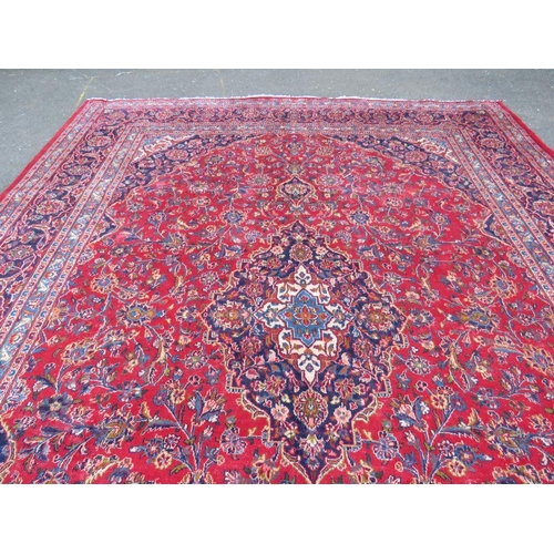 881 - A LARGE RED / BLUE GROUND CARPET, APPROX 389 X 297 CM - WEAR THROUGHOUT