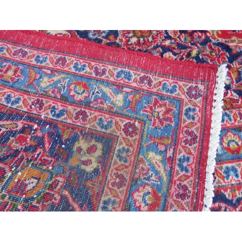 881 - A LARGE RED / BLUE GROUND CARPET, APPROX 389 X 297 CM - WEAR THROUGHOUT