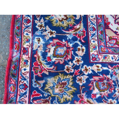 882 - A LARGE CARPET WITH RED CENTRAL GROUND AND BLUE BORDER, APPROX 360 X 270 CM - WEAR THROUGHOUT