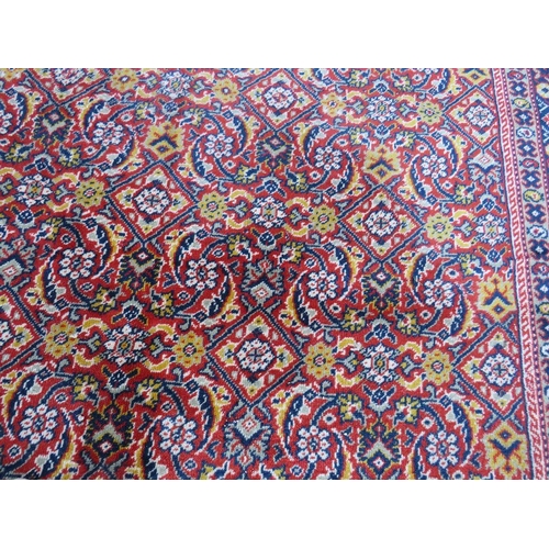 884 - A LARGE CARPET - RUST / TERRACOTTA GROUND WITH NAVY / YELLOW PATTERN, APPROX 365 X 253 CM - WEAR THR... 