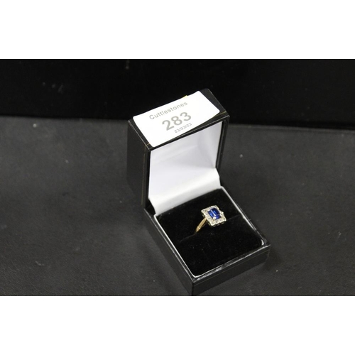 283 - A HALLMARKED 9CT GOLD RING SET WITH A CENTRAL BLUE STONE - APPROX WEIGHT 3.2 G