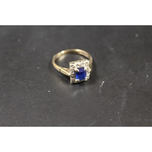 283 - A HALLMARKED 9CT GOLD RING SET WITH A CENTRAL BLUE STONE - APPROX WEIGHT 3.2 G