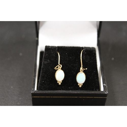 289 - A PAIR OF UNMARKED YELLOW METAL DROP EARRINGS SET WITH OVAL OPALS